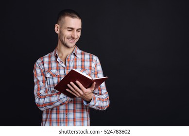 Cheerful Young Man Reading The Book