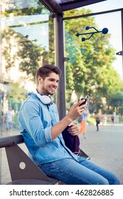 cheerful young man sitting at bus stop and   waiting