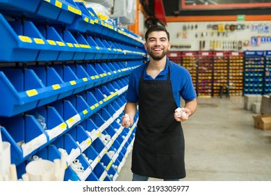 Cheerful young man smiling holding piping products for a customer while working at the hardware shop 