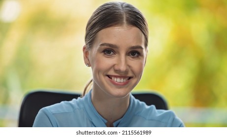 cheerful young manager smiling while looking at camera in office