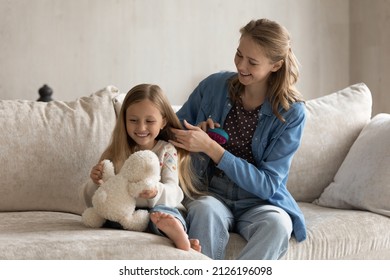 Cheerful Young Mother Enjoying Bare Of Happy Pretty Little Daughter, Brushing Long Girls Hair, Talking To Kid Playing With Toy, Laughing. Mom And Kid Getting Ready For School, Kindergarten In Morning