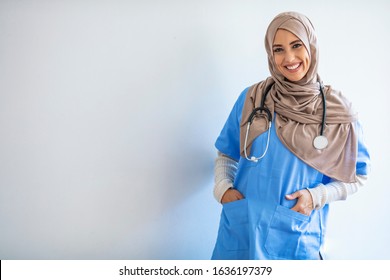 Cheerful young Muslim female nurse portrait, standing inside hospital. Arab female doctor posing and smiling isolated on a white background. Arab nurse woman wearing hijab over isolated background