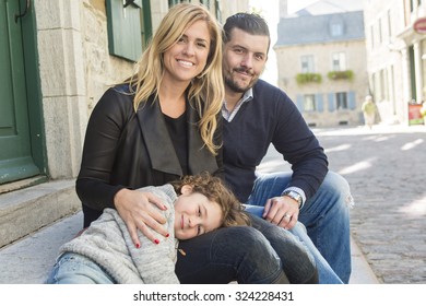 A Cheerful Young Parents With Kid In An Urban Scene 