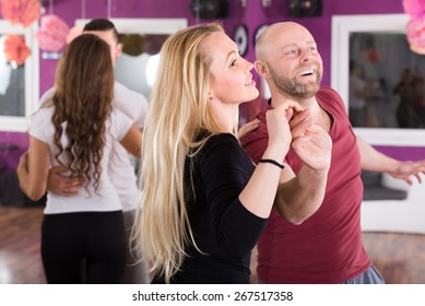 cheerful young people having dancing class indoors