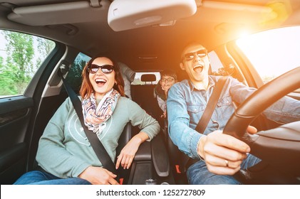 Cheerful young traditional family has a long auto journey and singing aloud the favorite song together.  Safety riding car concept wide angle view image. - Shutterstock ID 1252727809