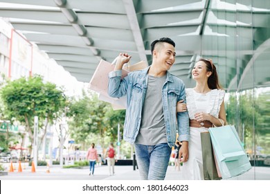 Cheerful Young Vietnamese Couple Walking In The Street After Shopping In Mall On Weekend