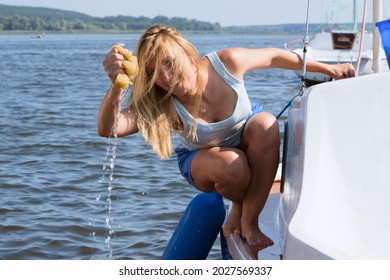 Cheerful young woman cleans a yacht, travel