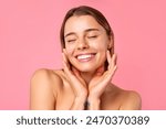 A cheerful young woman flashes a bright smile against a pink backdrop, showcasing her clear, radiant skin and natural beauty. Perfect for wellness, skincare, and positivity concepts.