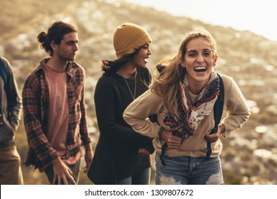 Cheerful Young Woman Laughing While Hiking With Social Networking Friends. Female Enjoying Hiking With Her Friends.