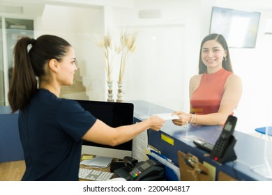 Cheerful Young Woman Receiving A Disk With The Medical Results Of Her Exams And X-rays Scans At The Medical Imaging Lab