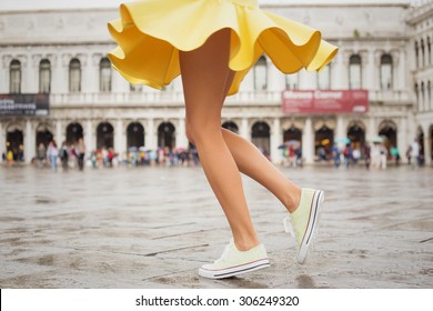Cheerful young woman with sexy legs and yellow skirt