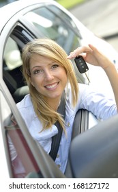 Cheerful young woman showing car key - Shutterstock ID 168127172