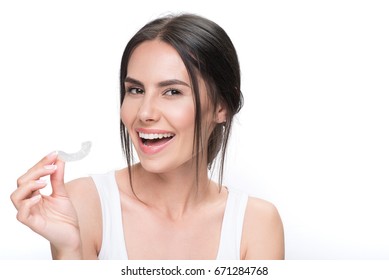 Cheerful Young Woman Showing Clear Aligner