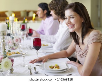 Cheerful Young Woman Sitting With Friends At Dinner Party