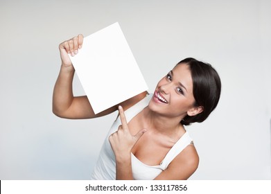 Cheerful Young Woman In White Singlet Holding Sign Over Gray Background