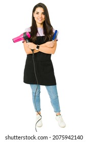 Cheerful young woman working as a hairdresser. Full length of a hairstylist using a hairbrush and blow dryer 