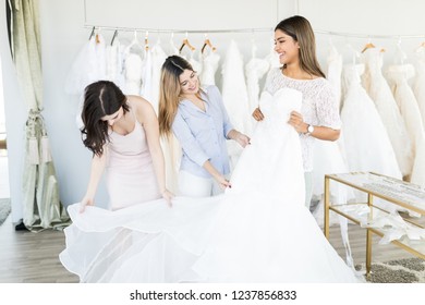 Cheerful Young Women Having Fun During Bridal Gown Fitting In Wedding Fashion Store