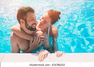 Cheerful Youthful Guy And Lady Resting While Swimming Pool Outdoor. Couple In Water.