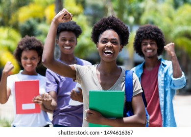 Cheering african female student with group of african american students outdoor in the summer - Shutterstock ID 1494616367