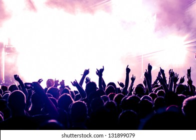 Cheering Crowd In Front Of Bright Purple Stage Lights