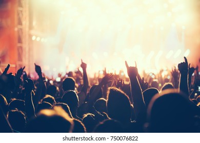 Cheering crowd with hands in air at music festival - Shutterstock ID 750076822