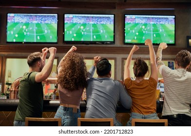 Cheering friends of soccer fans in the pub  - Shutterstock ID 2201712823