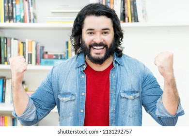 Cheering strong man with full beard indoors at home