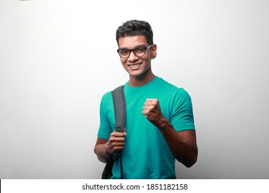 Cheering  successful young student of Indian origin carrying shoulder bag