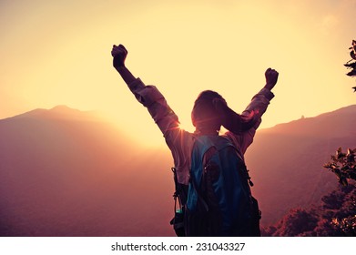 cheering woman hiker open arms at mountain peak  - Powered by Shutterstock