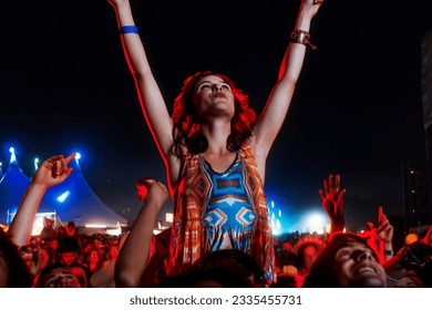 Cheering woman on man shoulders at music festival