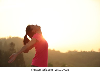 Cheering Young Asian Woman Open Arms At Sunrise Mountain Peak