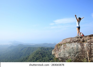 Cheering Young Woman Hiker Open Arms At Mountain Peak