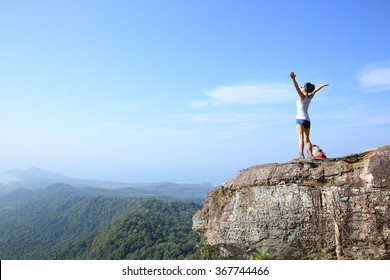 Cheering Young Woman Hiker Open Arms At Sunrise Mountain Peak