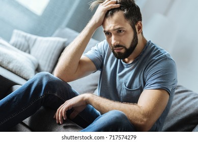 Cheerless moody man being alone - Shutterstock ID 717574279