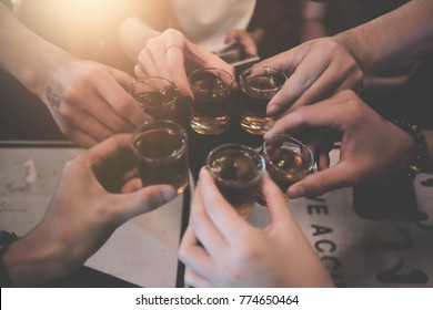 Cheers Clinking Of Friends With Bourbon Whisky Drink In Party Night After Work On Colorful Background