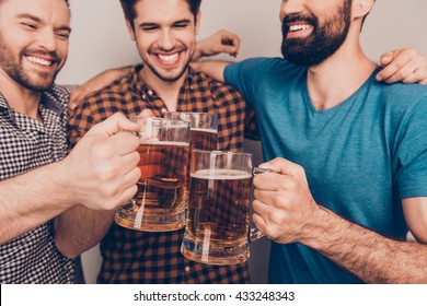 cheers! Close up photo of happy handsome men celebrating victory and clinking glass of beer - Powered by Shutterstock