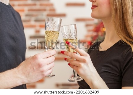 Cheers! Close up photo of two people holding glasses of shampagne on Christmas. Background.