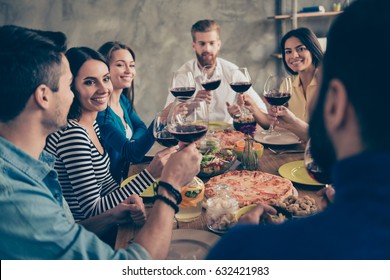 Cheers! Friends Got Together By Table With Delicious Food With Glasses Of Red Wine To Celebrate A Special Occasion