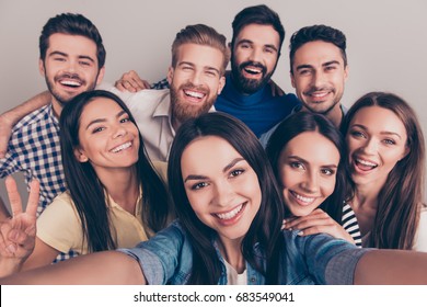 Cheers! Funky mood. Close up of an eight excited friend`s selfie, taken by brunette girl. Young people enjoy their company, smile, have fun - Powered by Shutterstock