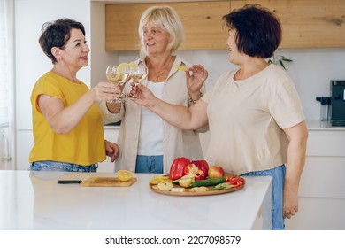 Cheers. Group Of Beautiful Middle Age Women Enjoying A Celebratory Toast Together In A Home.