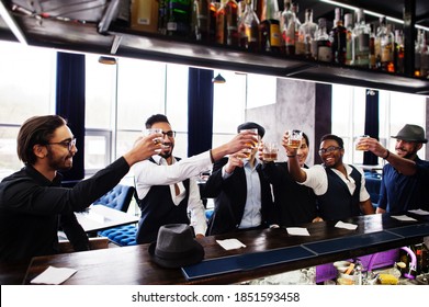 Cheers! Group Of Handsome Retro Well-dressed Man Gangsters Spend Time At Club. Drinking Whiskey At Bar Counter. Multiethnic Male Bachelor Mafia Party In Restaurant.