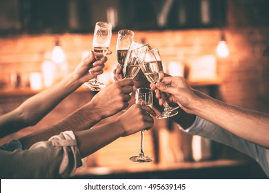 Cheers! Group of people cheering with champagne flutes with home interior in the background - Shutterstock ID 495639145