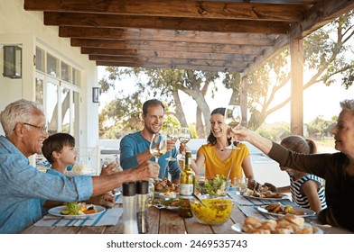 Cheers, wine and happy family on patio for lunch celebration, eating and bonding together at table. Children, men and women toast with glass, drinks and food in backyard for holiday, fun and relax - Powered by Shutterstock