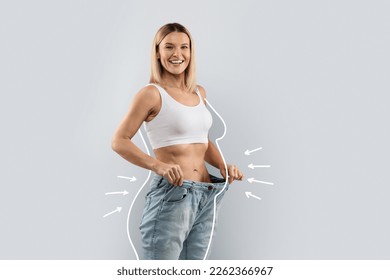 Cheery attractive slender middle aged blonde woman wearing huge jeans, showing results of diet, white body shape lines around happy slim lady, collage for slimming concept, copy space - Shutterstock ID 2262366967
