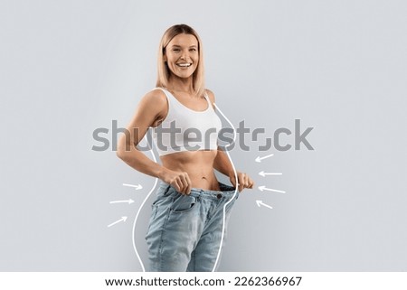 Cheery attractive slender middle aged blonde woman wearing huge jeans, showing results of diet, white body shape lines around happy slim lady, collage for slimming concept, copy space