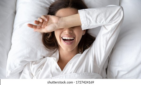 Cheery Woman Lie In Bed Woke Up After Sleeping, Hide Eyes From Sunlight In Morning, Enjoy New Day, Female Opened Mouth Laughs Has Wide Toothy Smile, Oral Hygiene, Dental Services, Enough Sleep Concept