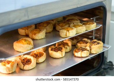 Cheese And Bacon Mini Quiches On Baking Trays In Commercial Oven.