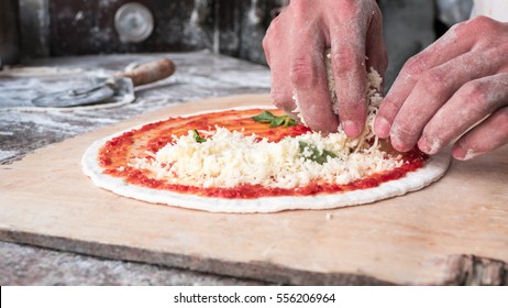 Cheese Being Spread On Tomato Sauce On Pizza Base. Selective Focus