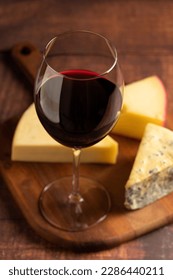 Cheese board with a glass of red wine. - Shutterstock ID 2286440211