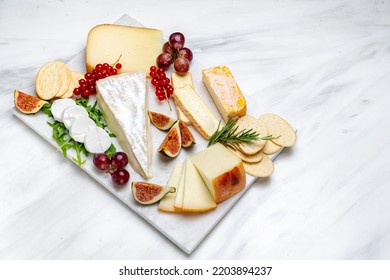 Cheese board with pecorino cheese brie goat cheese with crackers and grissini breadsticks, Italian and French cheese with figs jam olives and berries - Powered by Shutterstock